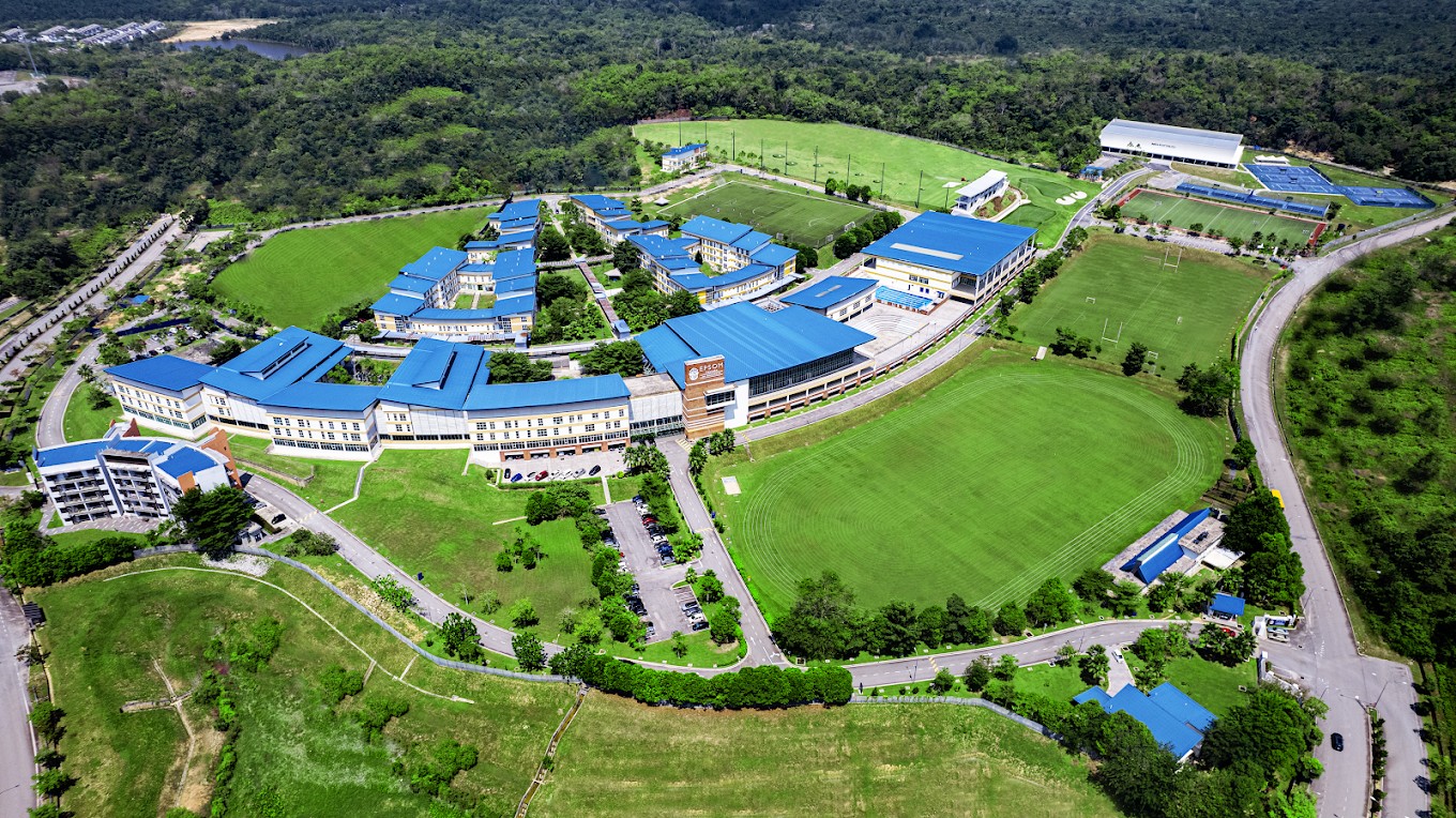 Aerial view of the school campus, surrounded by greenery and equipped with extensive academic, sports, and boarding facilities.