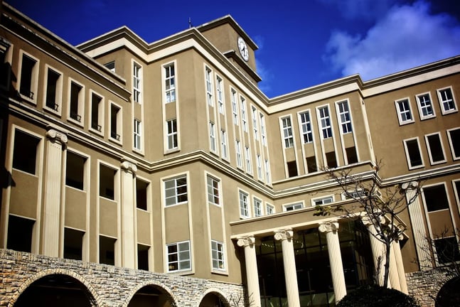 An exterior view of the multi-story school facility under a clear blue sky.