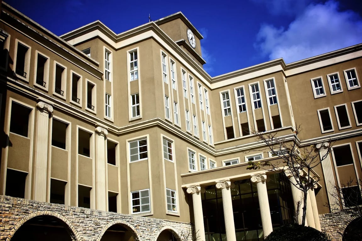 An exterior view of the multi-story school facility under a clear blue sky.