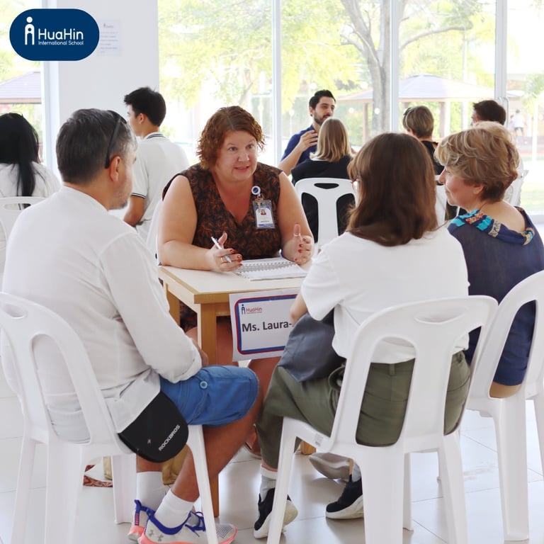 Parents and Teacher discussing their child's progress at a PT meeting.