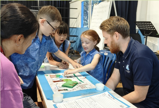 Students share their work with teachers during a school event.