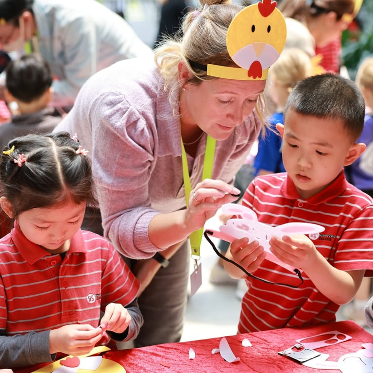 Primary students enjoying Easter bonnet crafting with PTA volunteers during a festive lunchtime event.
