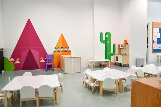 A classroom on campus, showing multiple learning spaces and a colourful painted wall