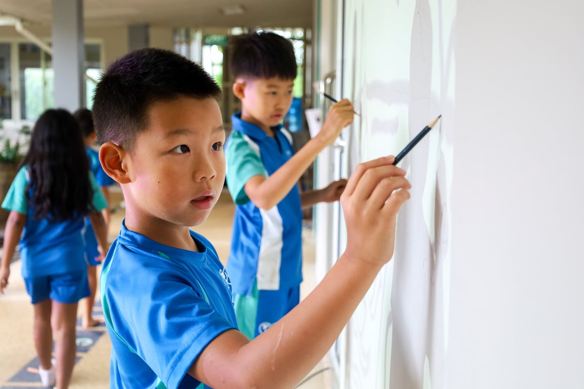 Grade 2 and 3 students sketching a mural in the Lower Primary Building.
