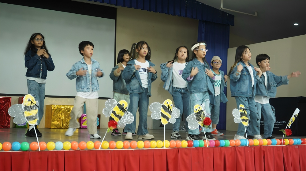 Primary students showcase a dance performance on stage.