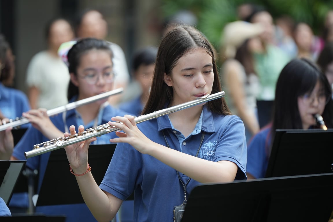 Student performing with the school band during a music recital.