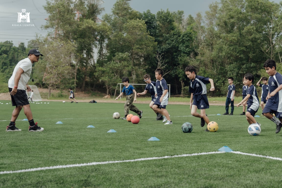 Students practicing dribbling skills during a football training session.