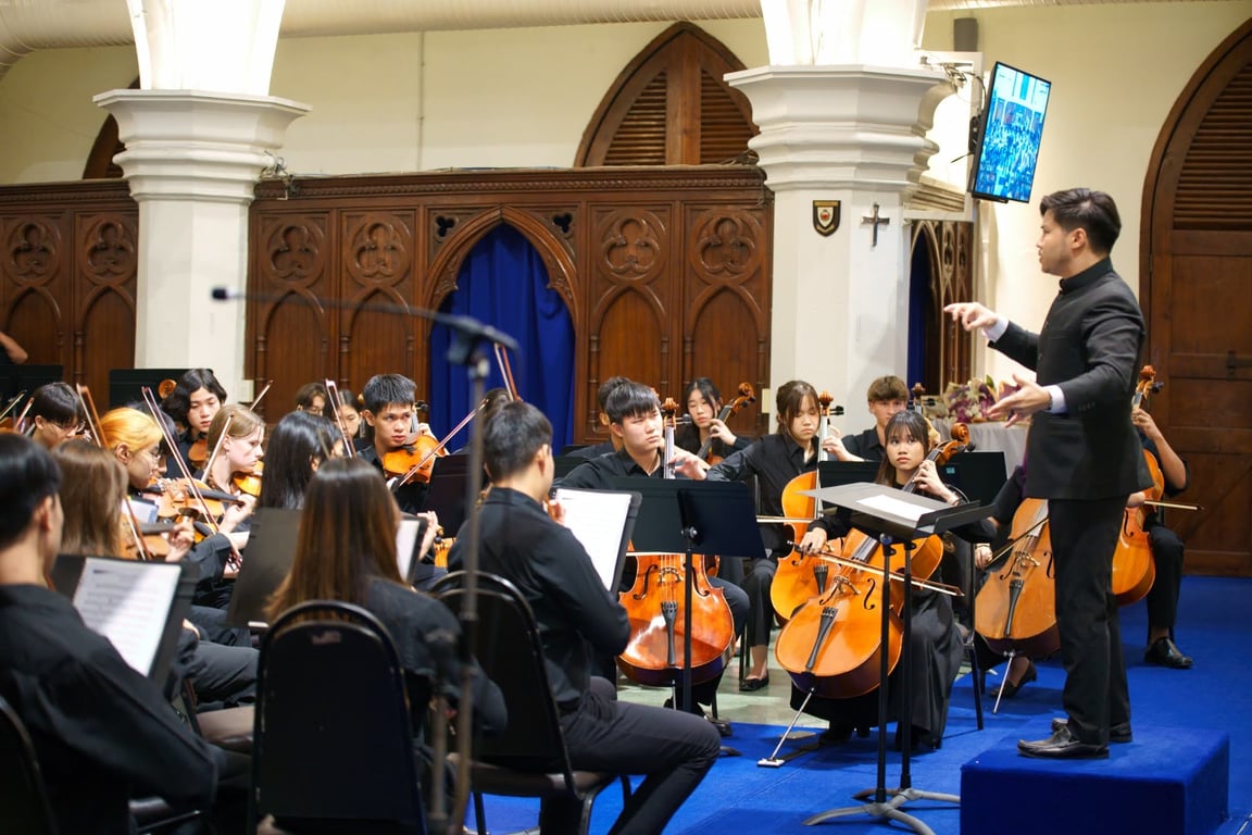 Students performing in a formal string orchestra concert.