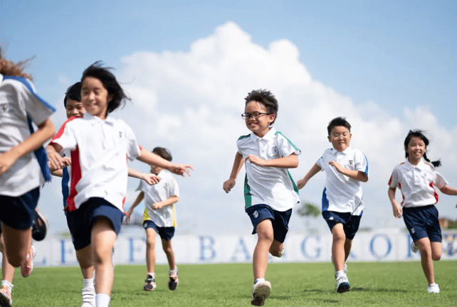 Primary school pupils running together during outdoor playtime.