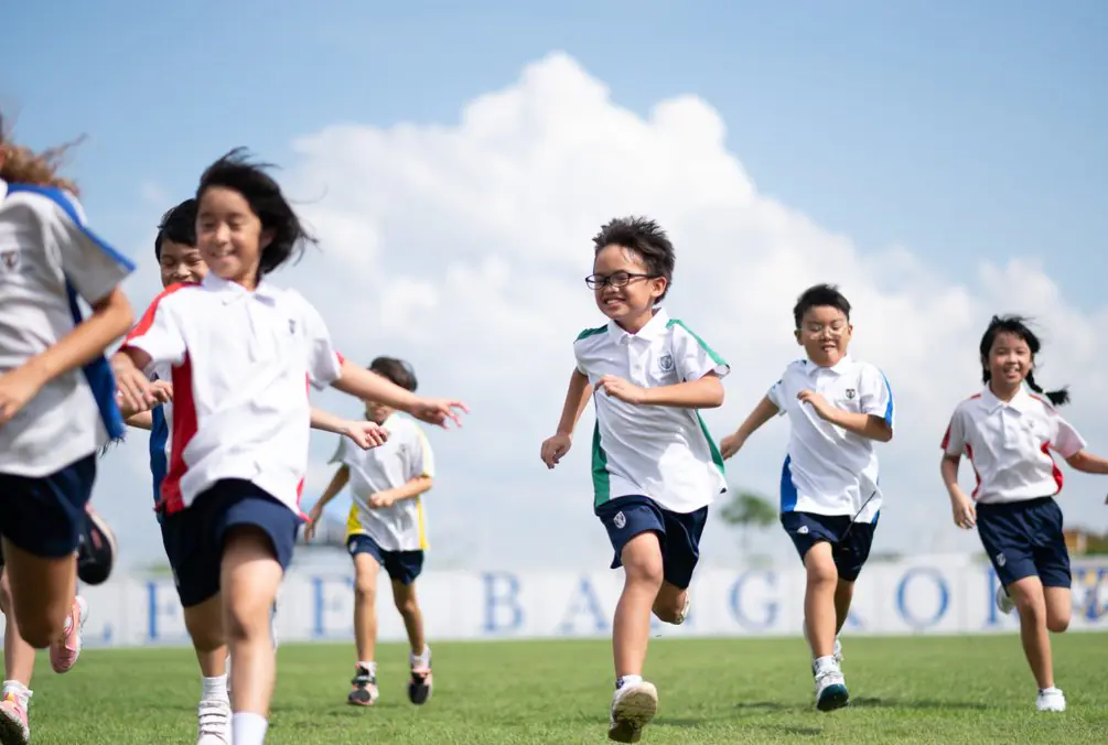 Primary school pupils running together during outdoor playtime.