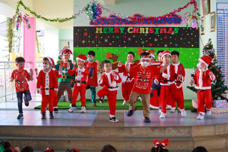 Students in Santa costumes performing on stage for Christmas.