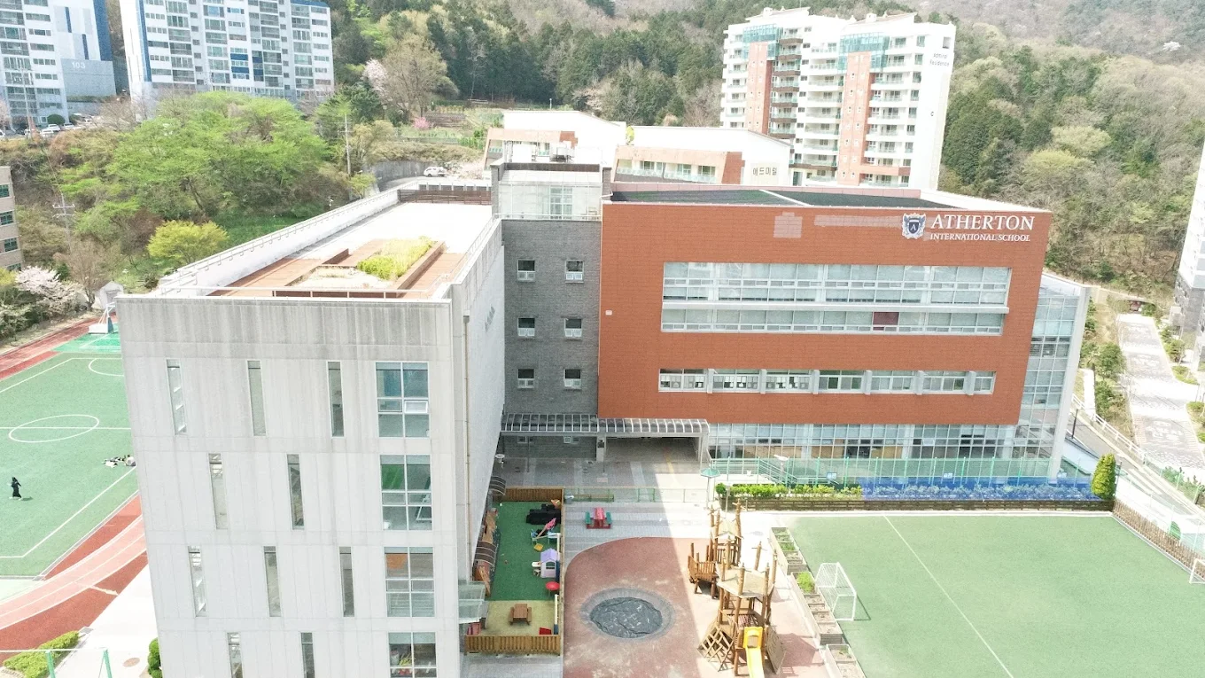 Atherton International School campus with playgrounds and sports courts.