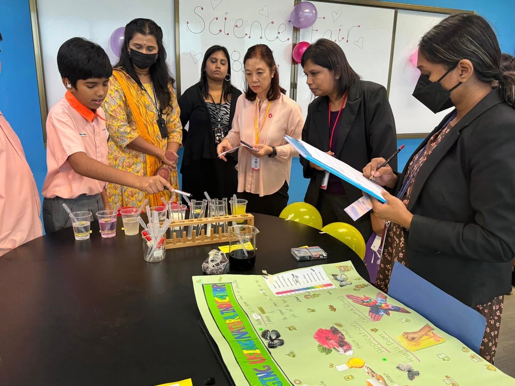 Students presenting a science experiment to teachers.