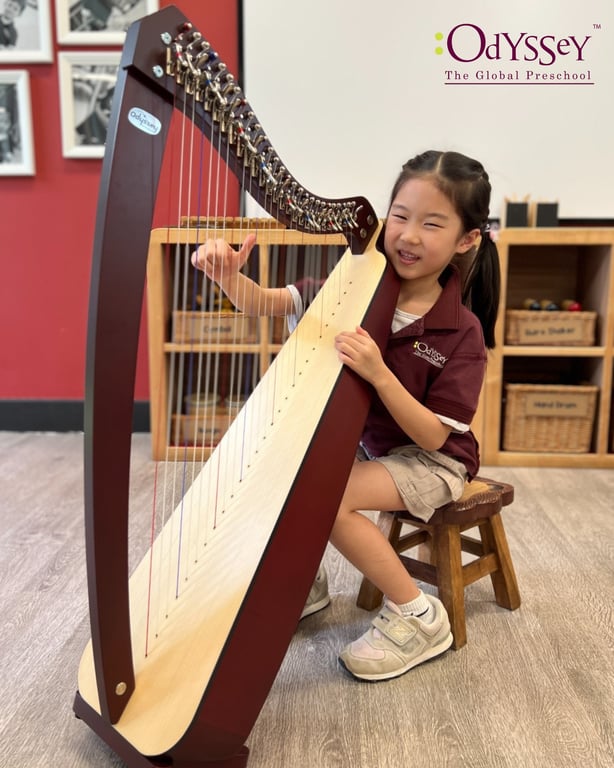 A student playing the Harp as part of the music program at Orchard Odyssey.