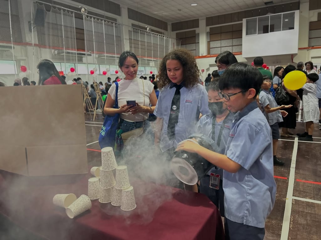 A parent engaging with one of the students science project.