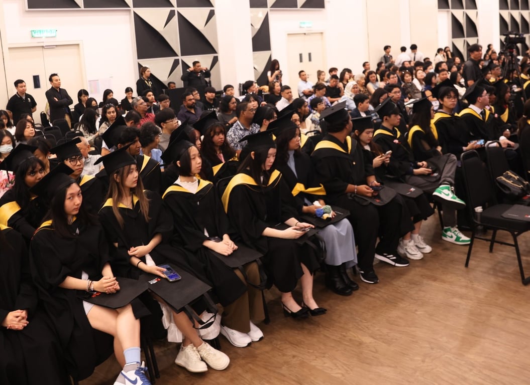 Graduating students seated with families.