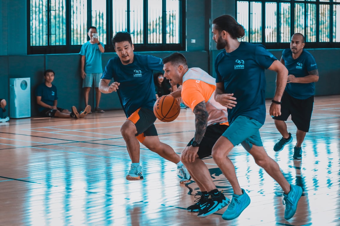 Parents and Teachers competing in a basketball match during the LANNA Community Cup.