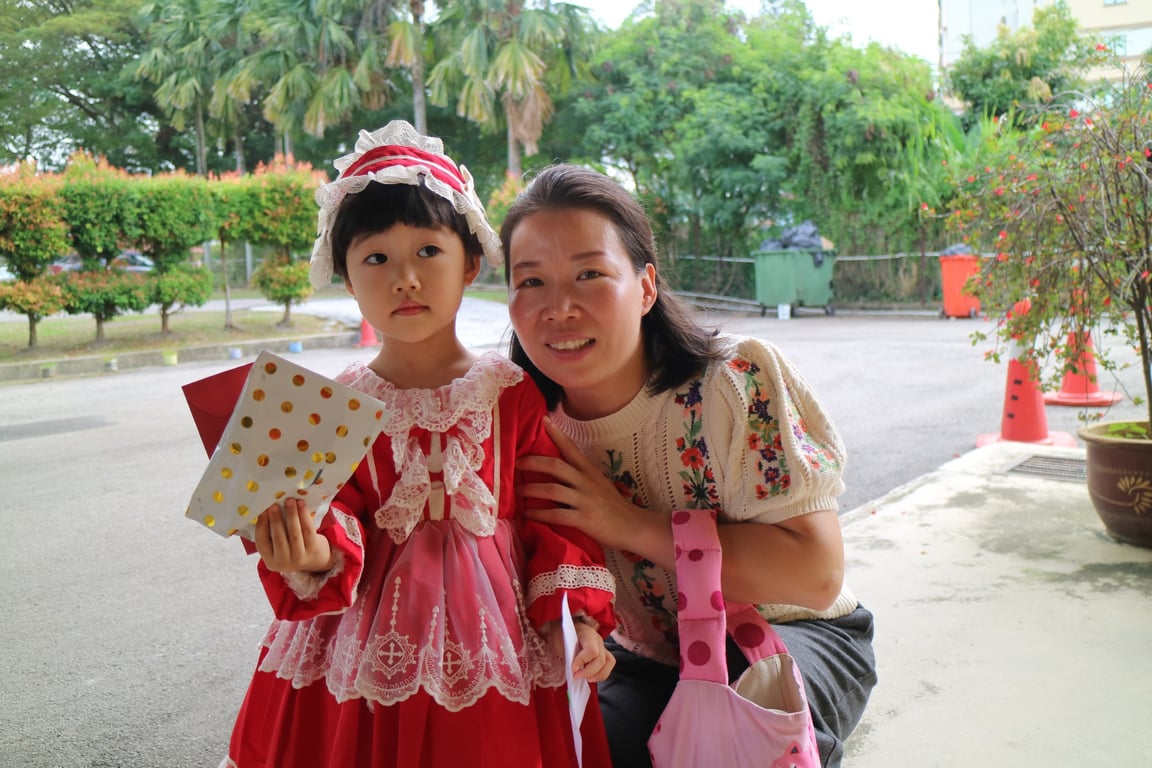 A young student in a period costume celebrates Costume Day with her parent, highlighting early years creativity and parental involvement.