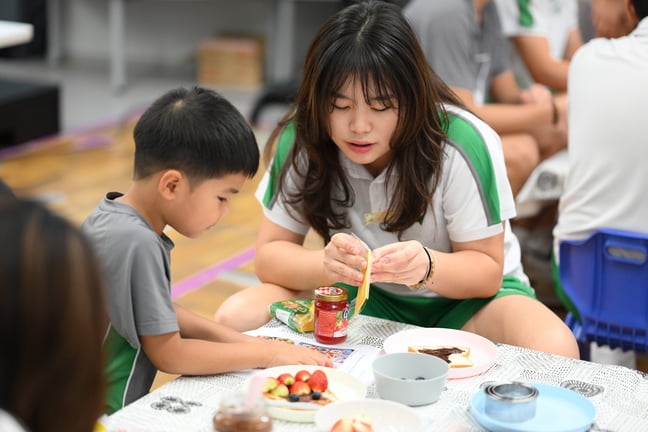 A senior student helping a younger one.