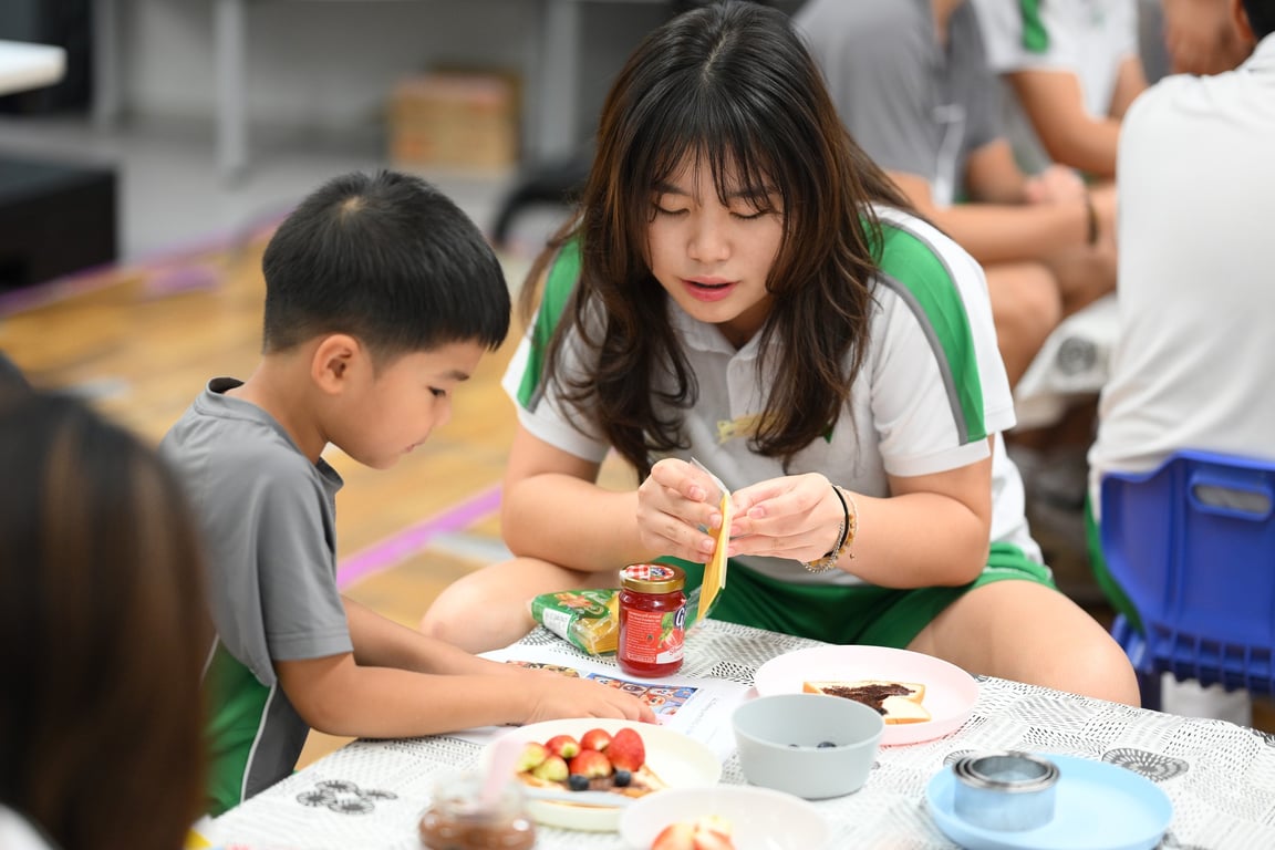 A senior student helping a younger one.