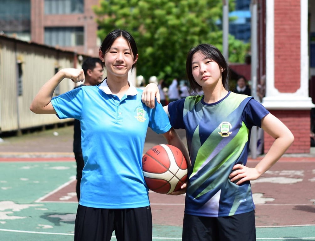 Two students posing with a basketball after practice.