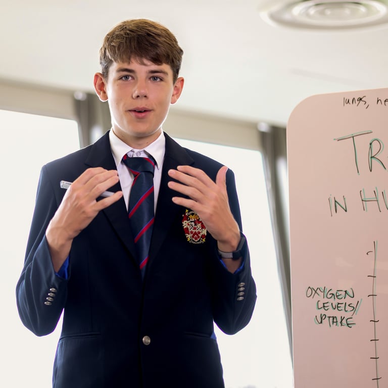 A student leads a science presentation in class, demonstrating confidence in communication and subject knowledge.