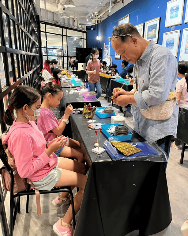 Children engage in a hands-on craft activity, guided by a teacher.