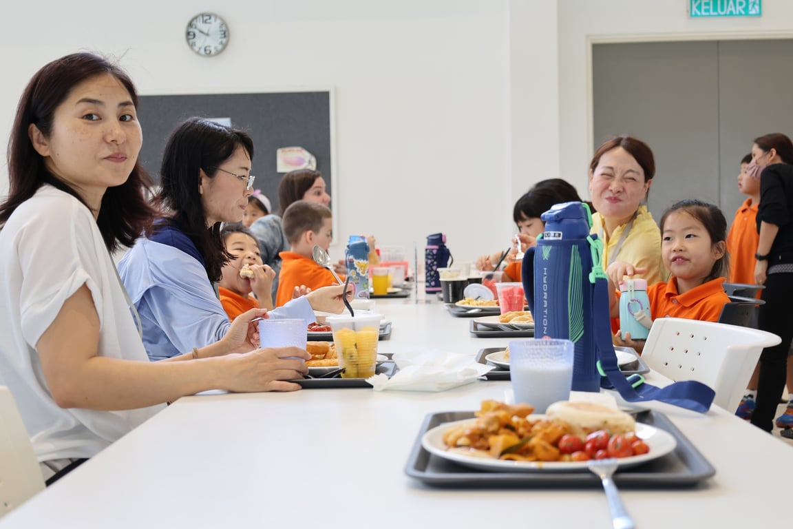 Families having lunch together in the cafeteria  on the first day of school.