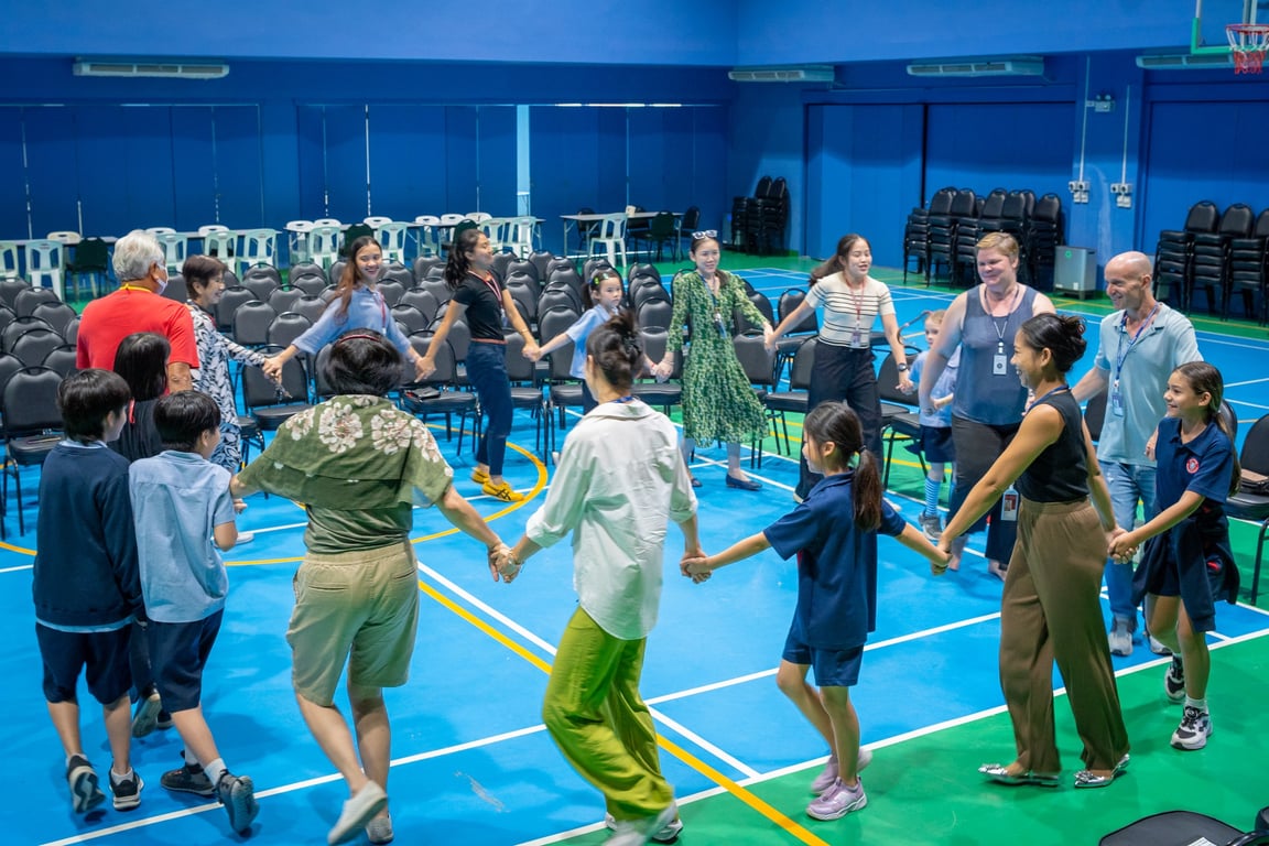 Families and students dancing together at the Folk Dance Fest.