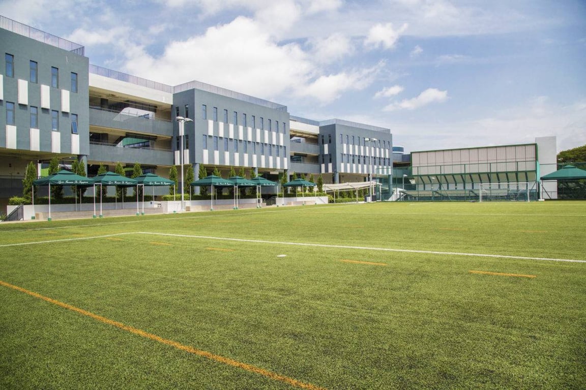A view of the school buildings, with the rugby and football pitches in the foreground
