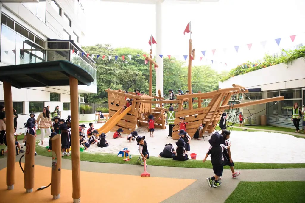 Students playing in the The Shipyard, signature pirate ship-themed playground created for students to actively explore their senses and imagination