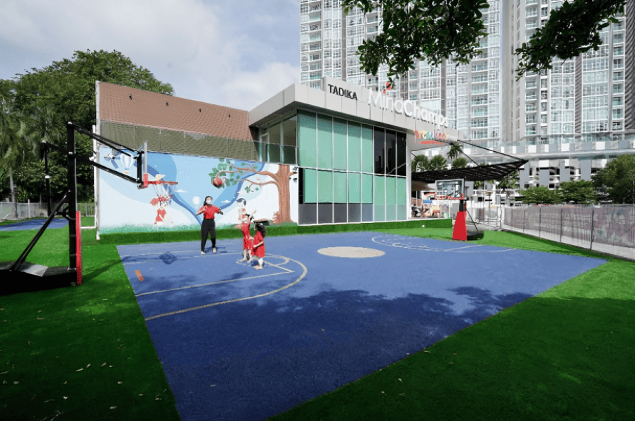 Children enjoy a fun basketball session with teacher at the vibrant outdoor play court.