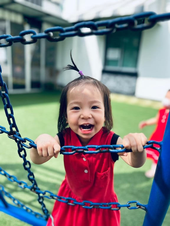 A child happily playing in the outdoor playground