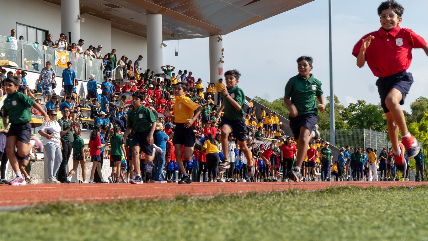 Students, teachers, parents, and staff celebrate during a race on Sports Day.