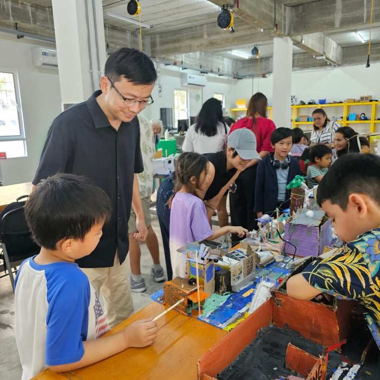 Families visiting student-designed model cities during the Community Heroes showcase.