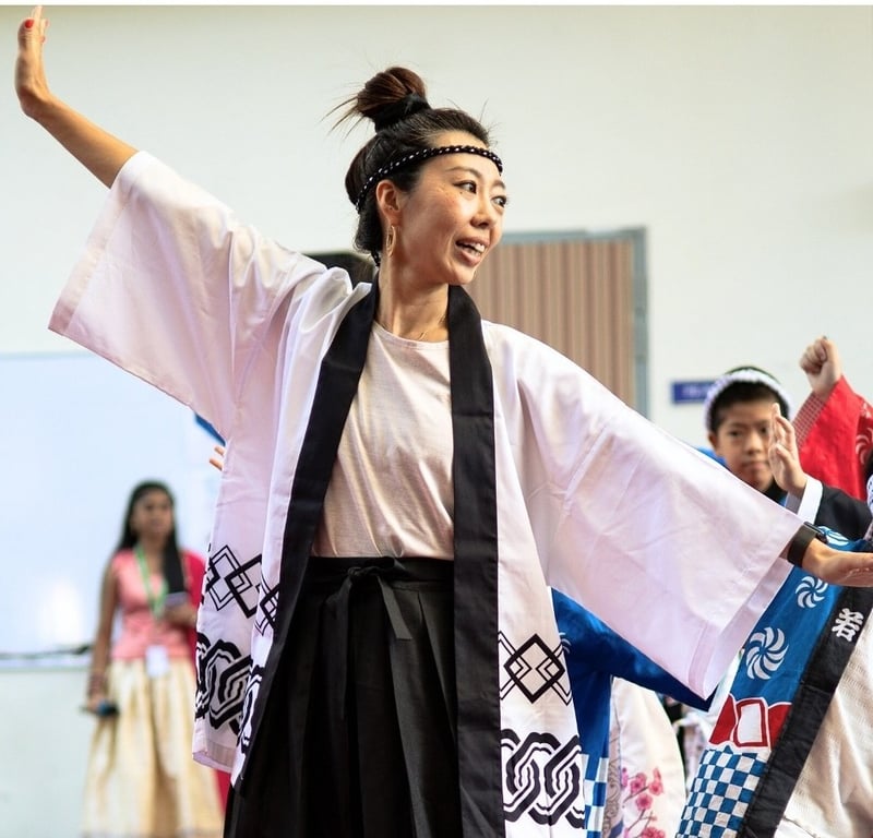 Teacher leading a traditional Japanese dance during cultural celebration.