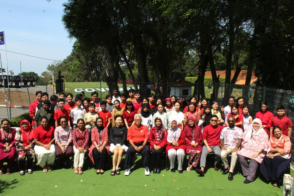 Staff and students gather for a group photo in celebration of a multicultural event on campus.
