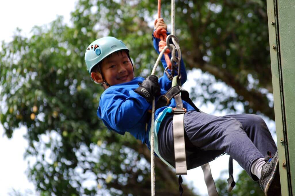 A brave student takes part in an outdoor climbing activity during KIS EDM. 