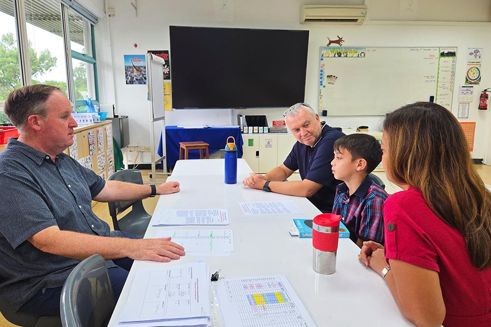 Parents connecting with teachers to discuss their child's progress and learning.