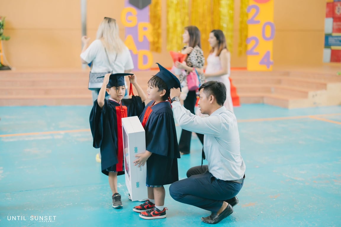 Parent helping child with gown and cap before graduation.