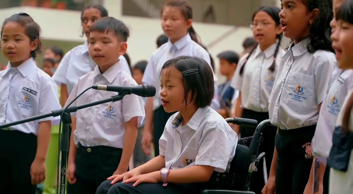 Primary students singing together during a school assembly