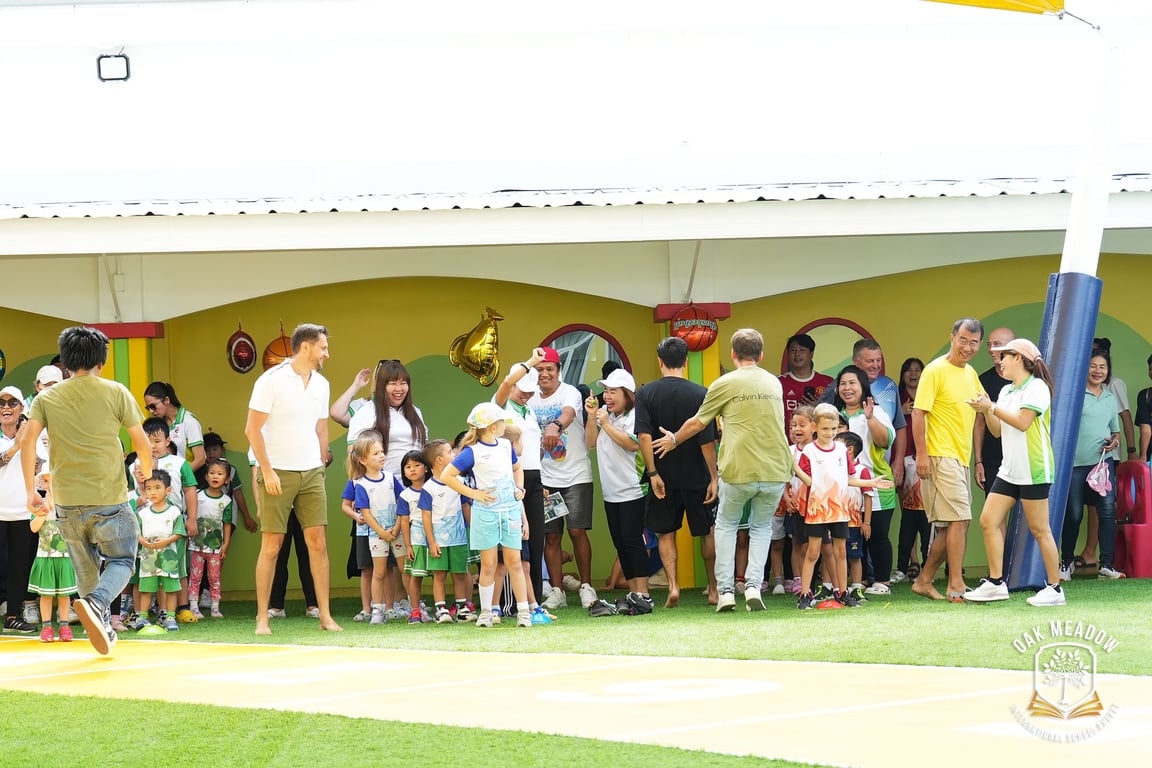 Parents and staff cheering on children during the annual sports day event.
