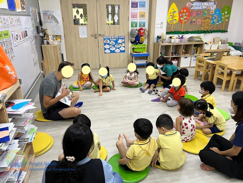 A parent reading a book to the kids in the classroom.