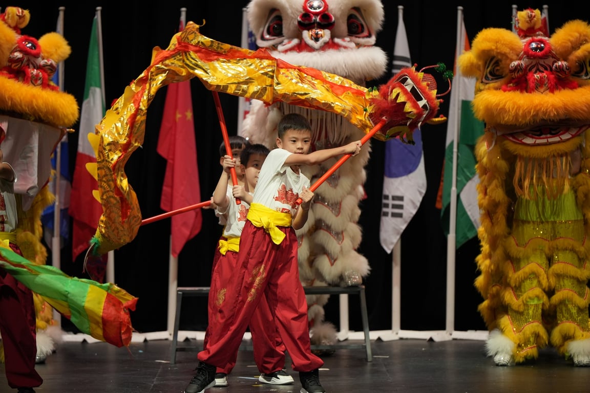 A student performing a dragon dance during a school cultural program.
