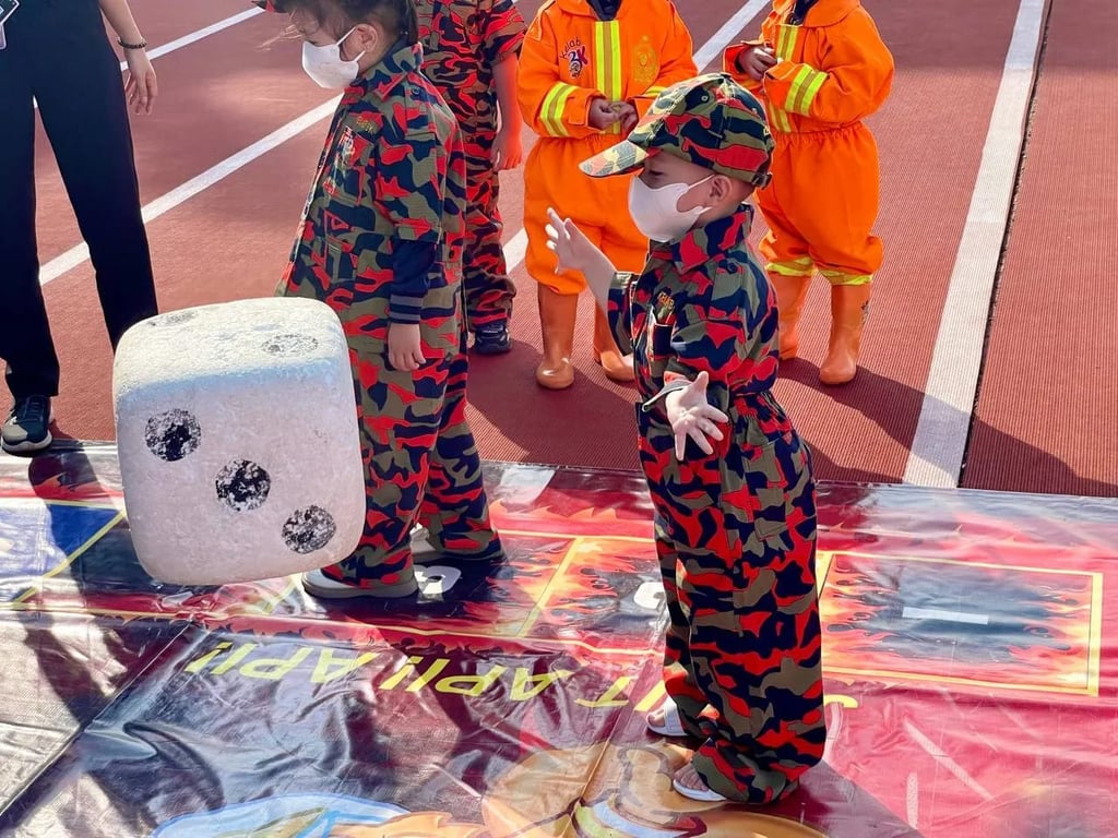 Kindergarten students take part in a life-sized “Safety Monopoly” board game, rolling giant dice and learning emergency preparedness through play-based learning.