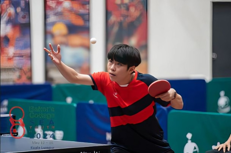 A student competes in a table tennis tournament, showing focus and agility.