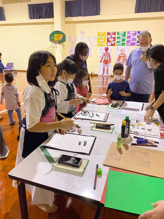 Students learning Japanese calligraphy during a cultural activity.