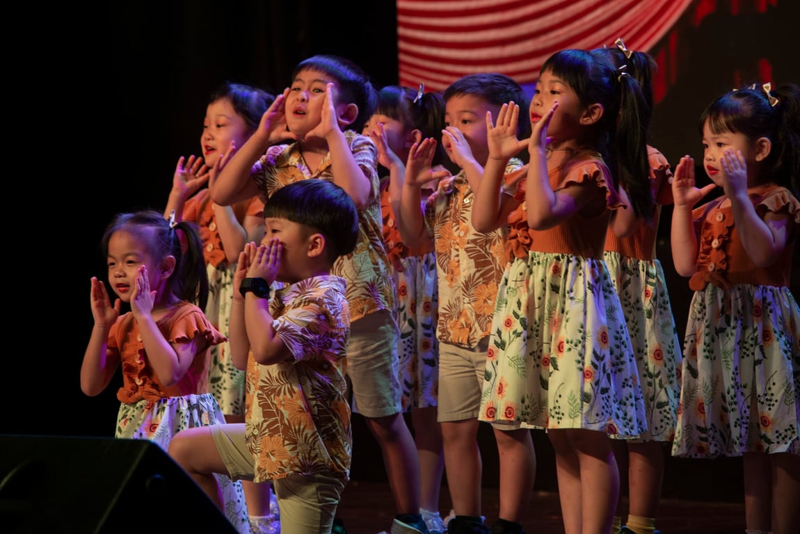 Kindergarten students perform a cheerful musical number during a school concert, celebrating expression through rhythm and voice.