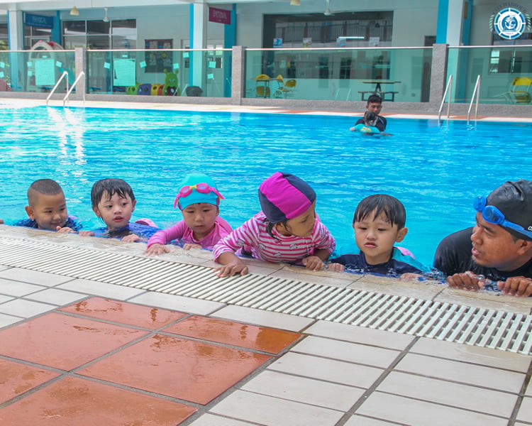 Young students during a swimming lesson with their coach.