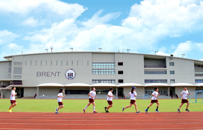 An exterior view of the main academic building and expansive athletic field.